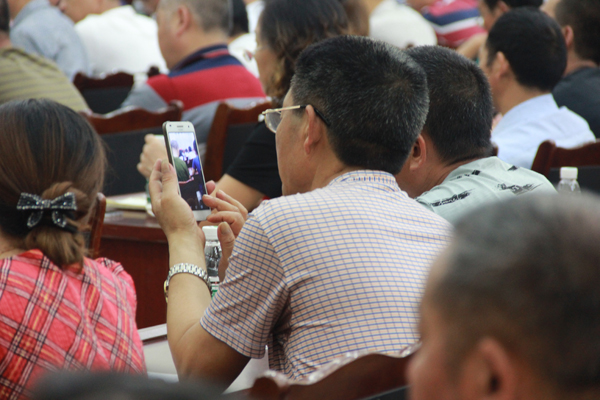 图为 参会人员违反会议纪律会议期间玩手机